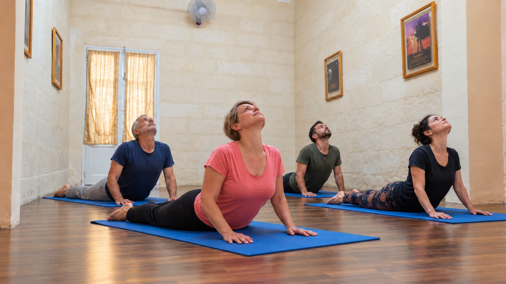 An indoor class practising cobra pose in the Malta yoga classroom
